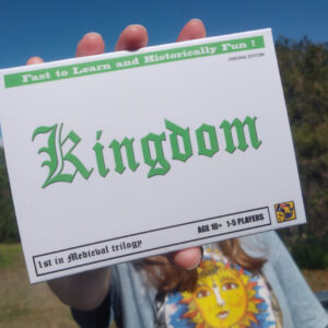 young person holding a card game called KINGDOM by BMK Workshop
